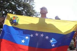 Venezuelano mostra bandeira do país em protesto feito em Campo Grande (Foto: Osmar Veiga)