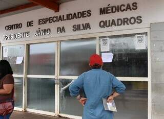 Homem lê o comunicado fixado na porta do CEM, avisando sobre o ponto facultativo (Foto: Osmar Veiga)