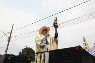 Em trio elétrico, padre Irineu segura imagem de Nossa Senhora Aparecida, durante carreata em Bandeirantes (Foto: Paulo Francis)