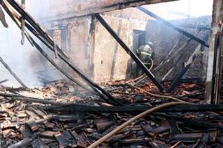 Bombeiro na varanda da casa que foi destruída pelo incêndio. (Foto: Henrique Kawaminami)