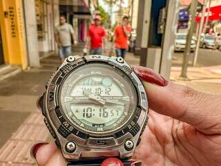 Relógio segurando por mulher no centro de Campo Grande (Foto: Marcos Maluf)