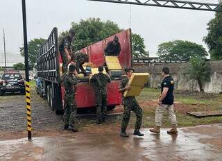 Militares e policiais descarregam fardos de maconha de carreta apreendida na MS-156 (Foto: Divulgação)