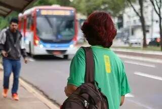 Estudante espera ônibus em avenida da Capital. (Foto: Arquivo/Alex Machado)