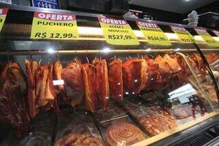 Expositor dos cortes de carnes em um açougue, com placas de ofertas fixados no vidro (Foto: Paulo Francis)