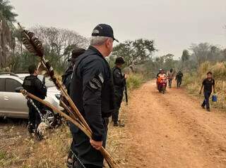 Policial segurando o arco e flecha de indígenas do Território Cerro Marangatu, em Antônio João, apos acordo de setembro (Foto: Polícia Militar)