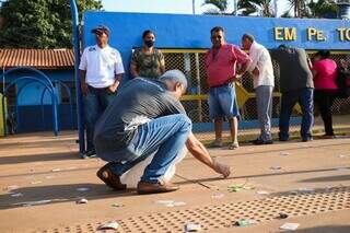 No dia 6, servidor da Justiça Eleitoral recolheu santinhos espalhados em local de votação (Foto: Arquivo/ Henrique Kawaminami)