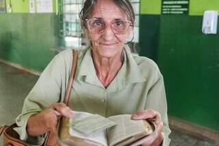 Aurea abre a bíblia que carrega para mostrar onde guarda o título de eleitor (Foto: Henrique Kawaminami)