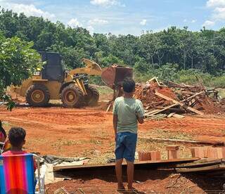 Criança assiste casa sendo destruída por patrola em terreno da prefeitura (Foto: Marcos Maluf)