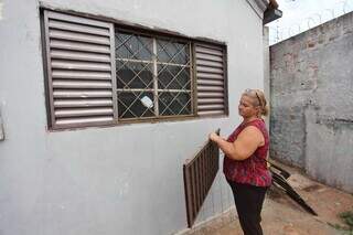 Elida mostra janela que foi quebrada após sua casa ser invadida (Foto: Paulo Francis)