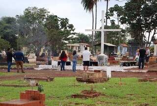 Familiares em frente à cruz, fazendo suas preces aos entes queridos (Foto: Osmar Veiga)