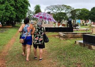 Janete (esq) e mãe procuram os túmulos de parentes no Cemitério São Sebastião (Geniffer Valeriano)