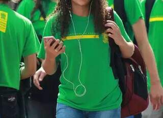 Estudante da rede estadual de ensino utiliza celular na saída da escola (Foto: Arquivo/Campo Grande News)  