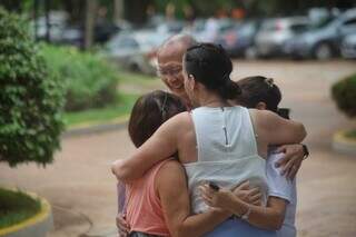 Voluntária dando abraço em família que foi visitar ente querido no cemitério (Foto: Paulo Francis)