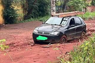 Carro ficou atolado após rua ser tomada por lamaçal (Foto: Direto das Ruas)