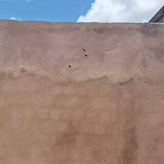 Marcas de tiros no muro da casa da vítima (Foto: Direto das Ruas)