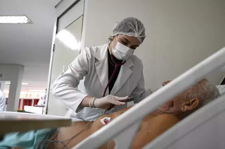 Enfermeira atende paciente durante internação em hospital. (Foto: Arquivo/Campo Grande News)