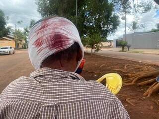 Vítima com a cabeça enfaixada, escorrendo sangue (Foto: Clara Farias)