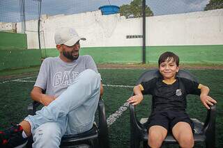 Paulo (pai) e Cauã sentados em cadeira em campo de society (Foto: Paulo Francis) 