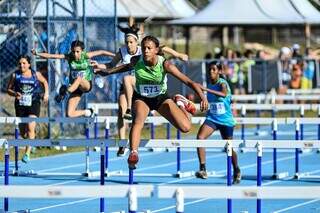 Estudante-atleta disputando prova de atletismo com barreiras (Foto: Fundesporte)