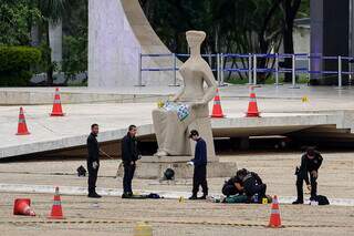 Policiais periciando o corpo do autor do atentado em frente do STF (Foto: Fabio Rodrigues-Pozzebom/ Agência Brasil)