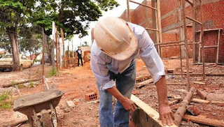 Trabalhador faz o corte de madeira, durante obra de residência na Capital. (Foto: Arquivo/Campo Grande News)