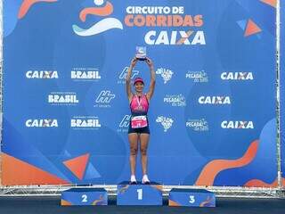 Vencedora da prova de 10 km feminino, Janine Rodrigues de Oliveira, recebe troféu e medalha da Corrida da Caixa (Foto: Marcos Maluf)