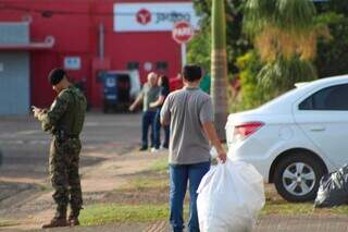 Homem carrega saco com objetos retirados de transportadora (Foto: Juliano Almeida)