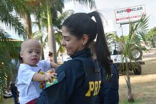 Policial segura um paciente da AACC/MS no colo (Foto: Divulgação)