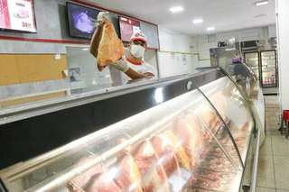 Açougueiro segurando pedaço de carne em açougue. (Foto: Arquivo/Henrique Kawaminami)