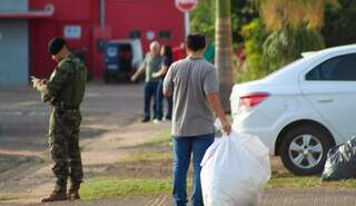 Homem carrega saco com objetos retirados de transportadora (Foto: Juliano Almeida)