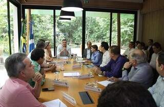 Governador Eduardo Riedel (PSDB) na ponta na mesa, em reunião com a bancada federal de MS (Foto: Álvaro Rezende)