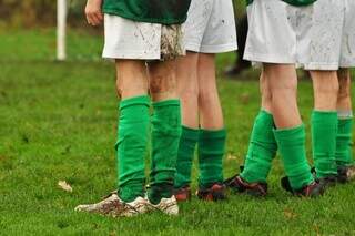 Crianças jogam futebol em gramado. (Foto: Depositphotos)