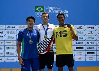 Sul-mato-grossense Daniel Coelho (de amarelo) exibe medalha de bronze, que conquistou nos 100 metros peito (Foto: Divulgação/André Durão/COB)