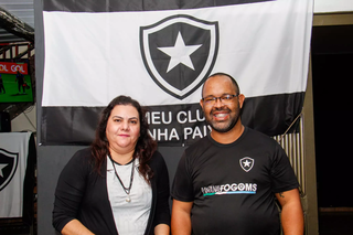 Camila e Leonardo em frente a bandeira do Fogão em entrevista ao Campo Grande News (Foto: Juliano Almeida) 