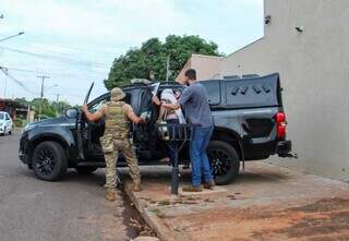 Mãe do rapaz morto entra em viatura para prestar depoimento na delegacia. (Foto: Juliano Almeida)