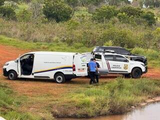 Viaturas da PM, Polícia Científica e carro funerário nas margens do córrego onde corpo foi encontrado. (Foto: José Portela/Nova News)