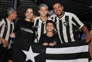 Família de Tico e Vinícius Pereira segurando bandeira na sede da Pantanal Fogo (Foto: Osmar Veiga)