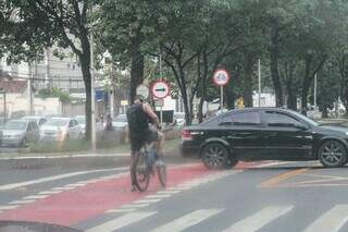 Ciclista toma chuva na região central de Campo Grande (Foto: Marcos Maluf)