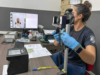 Perita da Polícia Cívil tirando foto de homem para novo RG, em Campo Grande. (Foto: Arquivo/Marcos Maluf)