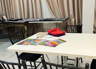 Mesa com as cartilhas usadas nos exames e, ao fundo, as armações de óculos (Foto: Divulgação)