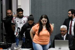 Stephanie (laranja) e Christian (branco) entram no plenário para julgamento (Foto: Henrique Kawaminami)