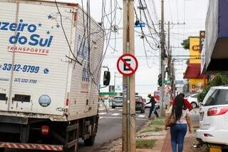 Caminhão passa próximo da fiação solta: risco de acidente (Foto: Henrique Kawaminami)