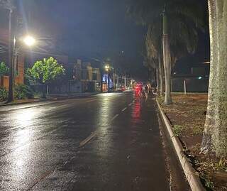 Chuva rápida deixou ruas molhadas na noite desta sexta-feira (13), em Dourados. (Foto: Helio de Freitas)