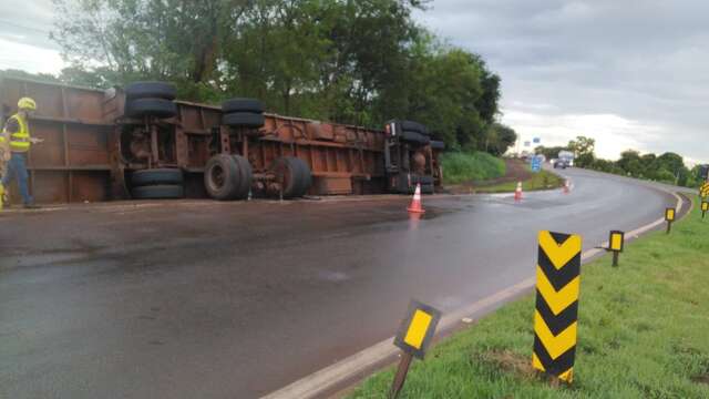 Motorista tomba carreta e espalha carga de serragem &agrave;s margens de rodovia