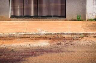 Sangue no chão em frente à casa onde ocorreram os fatos. (Foto: Henrique Kawaminami)