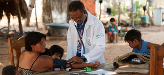 Médico contratado pelo programa atende paciente em aldeia indígena (Foto: Alejandro Zambrana/Ministério da Saúde)