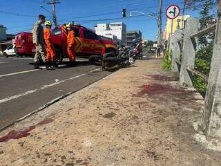 Sangue da vítima na calçada e moto ao fundo (Foto: Marcos Maluf)