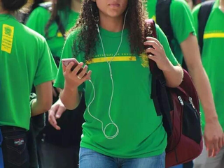 Estudante da rede estadual de ensino utiliza celular na saída da escola. (Foto: Arquivo/Campo Grande News)