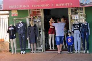 Comerciante em Campo Grande recolhendo produtos (Foto: Paulo Francis)