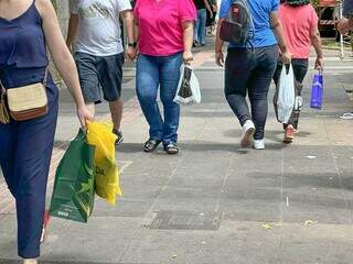 Consumidores com sacolas de presentes andando na Rua 14 de Julho (Foto: Marcos Maluf)